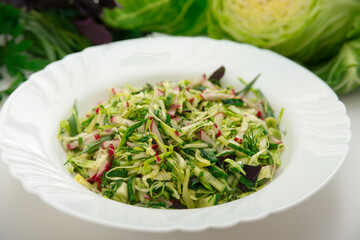 Fresh salad of white cabbage with tarragon on a white plate. Vegetarian and vegan food. A healthy and orangic dish.