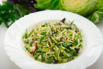 Fresh salad of white cabbage with tarragon on a white plate. Vegetarian and vegan food. A healthy and orangic dish.