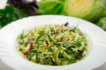 Fresh salad of white cabbage with tarragon on a white plate. Vegetarian and vegan food. A healthy and orangic dish.