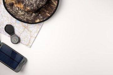 Flat lay solar battery, compas and traveler accessories on white background. travel concept. © Konstantin Maslak