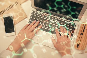 Double exposure of woman hands working on computer and formula hologram drawing. Top View. Science concept.