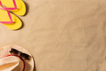 Fototapeta na wymiar Summer vacation composition. Flip flops and straw hat on sand