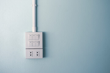 Double electrical power socket and single plug switched on, blue background.