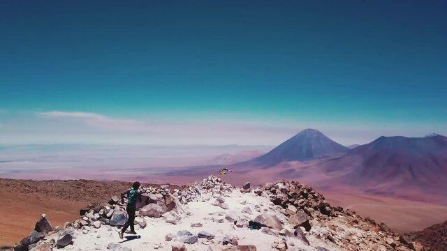 Male runner reaches the top of the desert mountain in the Atacama desert. 4k