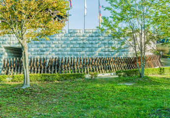Barrier of pointed projecting spikes in front of stone wall.