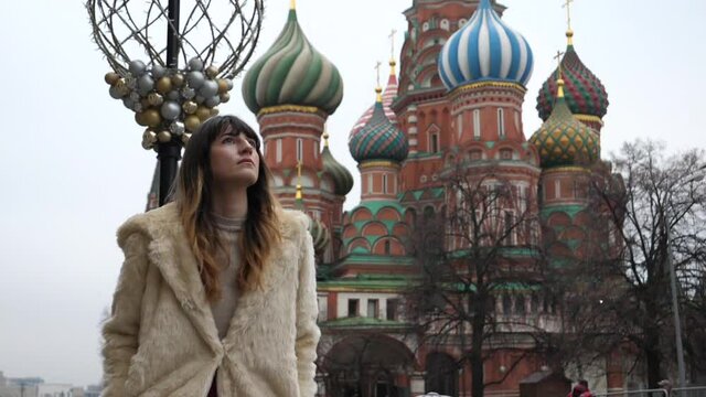 Beautiful woman walking in Moscow, St Basil's Cathedral background, slow motion