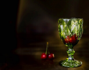 glass wine glass tableware glass aperitif green glass on a dark background cherry cherry splashes...