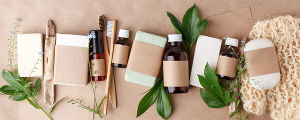 Fototapeta na wymiar Bath natural accessories and skin care cosmetics - solid soap and shampoo, bamboo toothbrushes, essential oils, zero waste theme on beige background with floral elements. Mock up, copy space