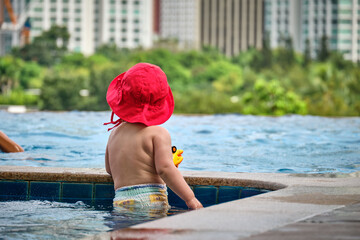 Manila, Philippines - Feb 02, 2020. Little girl in the pool on the roof of the hotel. View of the city of Manila from the pool of the luxury five-star Discovery Primea hotel. Sunny weather