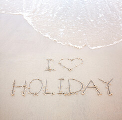 'I love holiday' handwriting word on the beach