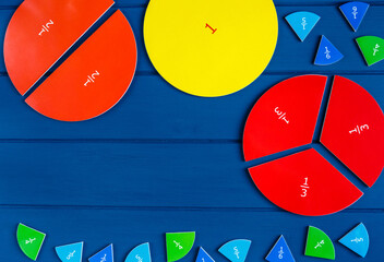 Close up mathematical fractions and colorful letters on blue background. Creative, fun mathematics...