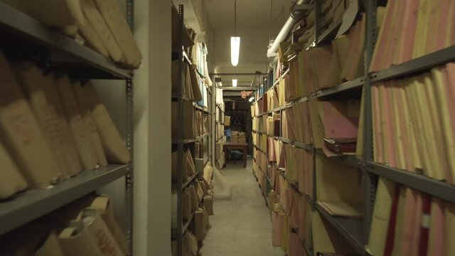 open shelf warehouse with files storaged at a old building , smooth movement of camera towards the warehouse , organize storage unit work busy day