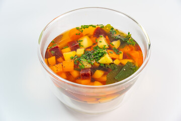 Vegetable soup in double walls glass bowl on white background