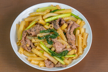 Homemade Chinese styled stir-fried beef noodle on white plate