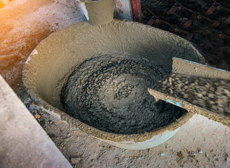 concrete mixer truck pouring concrete into large basin in construction site