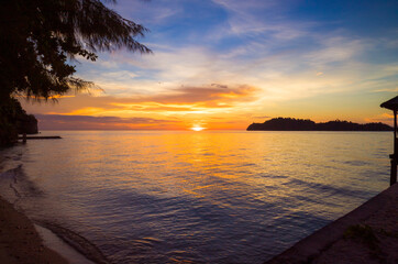 Fototapeta na wymiar beach at sunset with island in the background