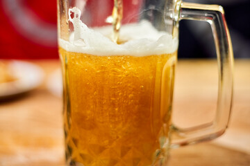 A glass of crafty beer. International beer day or Octoberfest concepts. Drinking beer after a hard working day in the pub. Watching football or soccer