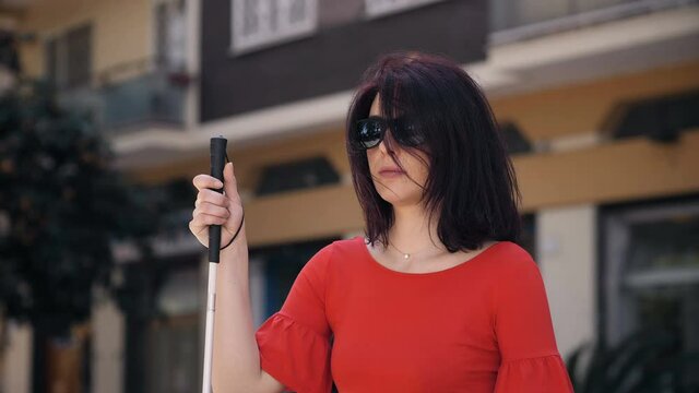 young worried blind woman in the street is afraid to walk alone