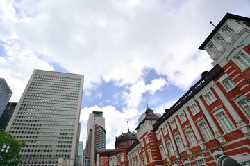 Fototapeta na wymiar 雲が多い夏日の空と東京駅を見上げた風景