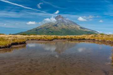 Mt. Taranaki reflected on a pond during a sunny day at New Zealand
