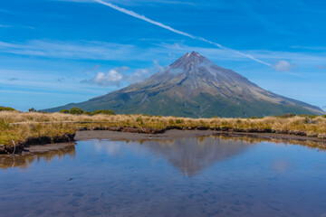 Mt. Taranaki reflected on a pond during a sunny day at New Zealand