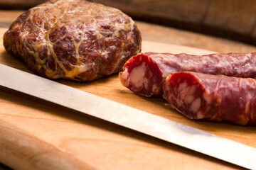 Salsiccia e salame su tagliere con coltello