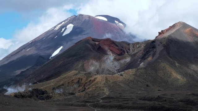 Path leads up a dramatic red volcano mount doom with slowly moving clouds - Slow panning shot