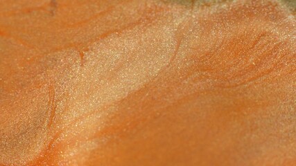 Orange, coral color liquid paint. Cosmetic glitter texture. Abstract background. Hypnotic mixing...