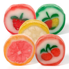 Five round fruit caramels on a white background