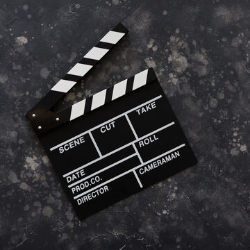 Filmmaking concept. Movie Clapperboard. Cinema begins with movie clappers. Movie clapper on a dark background. Square.