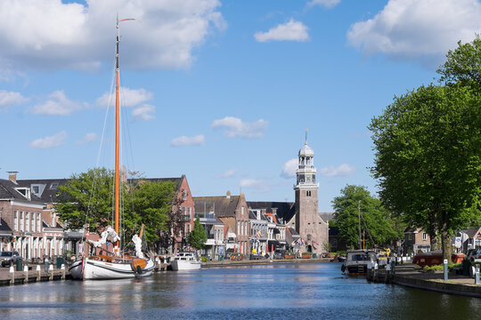 Yachts in the port of Lemmer in spring with reformed Church in Friesland, Netherlands