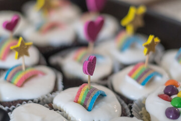 Isolated close up of multiple delicious decorated  cupcakes with whip cream and candy in a birthday...
