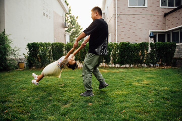 A pair of Asian father and daughter playing with water in the yard