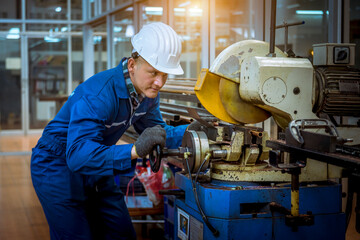The Industry engineering wearing safety uniform control operating lathe grinding machine working in industry factory.