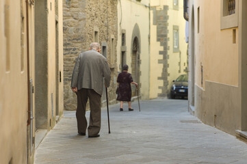 Old couple holding cane, walking along in street on September 16, 2013 in Arezzo, Italy