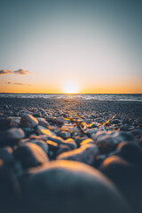 Obraz premium Sonnenuntergang an einem steinigen Strand an der Ostsee