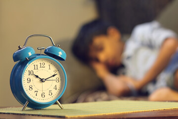 Indian young boy sleeping with alarm clock