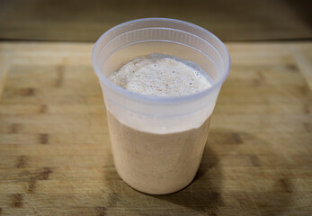 Bubbly sourdough starter after feeding, before mixing the dough for artisanal rustic sourdough bread, photo series