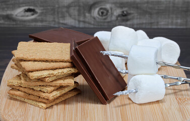 Chocolate squares, graham crackers, marshmallows and skewers.