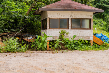 Fototapeta na wymiar Abandoned cabin with gravel parking