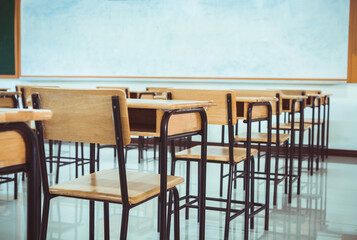 Lecture room, School empty classroom with desk chair iron wood for studying lessons in high school. No student in situation of Covid-19 disease outbreak result in inability organize teaching learning