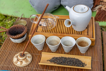 Tea ceremony at the outdoors camping site. Still life of appliances for tea consumption laid down on the tea table with tea and incense sticks.