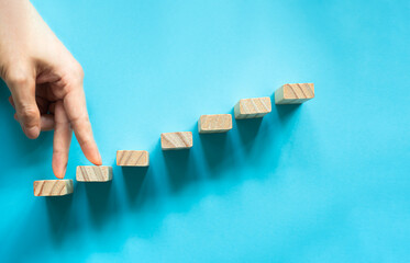 conceptual businessman fingers arranging  wooden blocks in the position