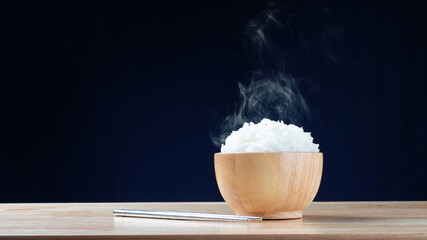 white cooked rice on bowl with hot steam on dark