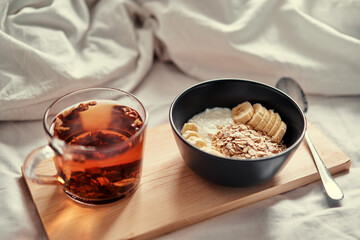 Good morning. Breakfast in bed. Bowl of granola and cup of hot tea.
