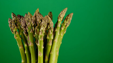 fresh asparagus green bunch on green background. place for text