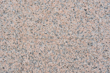 Closeup of granite tile on the wall. Stone beige spotted abstract background