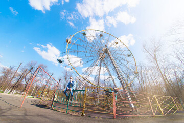 guy on the background of an empty ferris wheel in the park alone