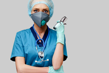 female doctor with stethoscope wearing protective mask and latex gloves over light grey background