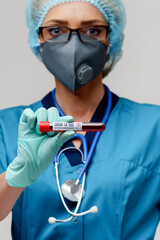 medical doctor nurse woman wearing protective mask and gloves - holding virus blood test tube